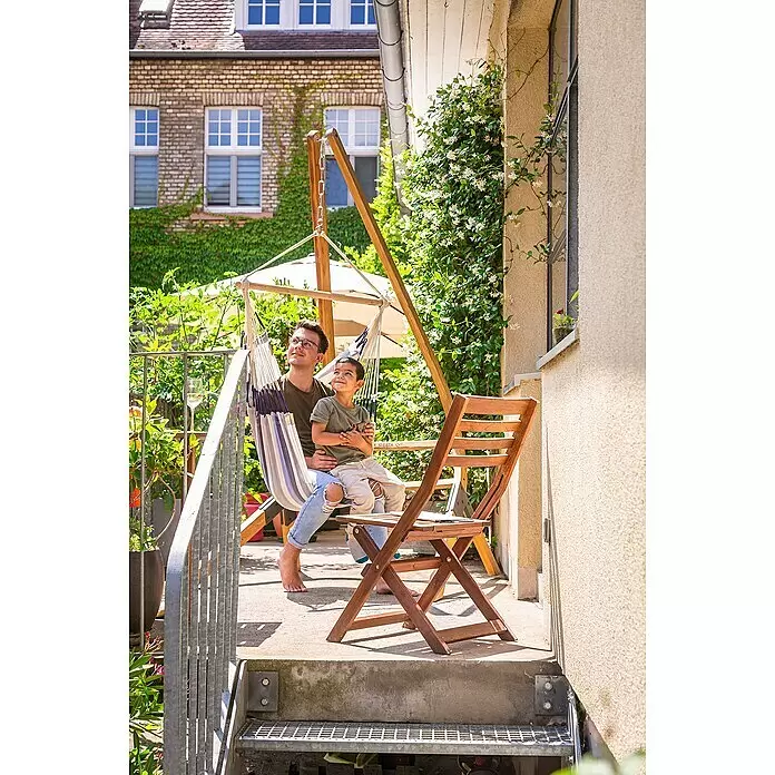 La Siesta Hängesessel Domingo Basic - L x B x H: 140 x 90 x 145 cm, Sea Salt - Mann und Kind entspannen in einem gestreiften Hängesessel mit Holzgestell auf einer Terrasse.