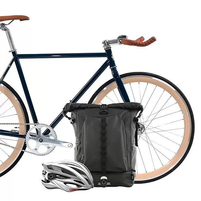 T'nB Linterna para bicicletas - Blanco - Bicicleta azul con neumáticos color crema, bolsa de bicicleta gris oscuro enrollable con luz integrada y casco plateado con luz trasera.