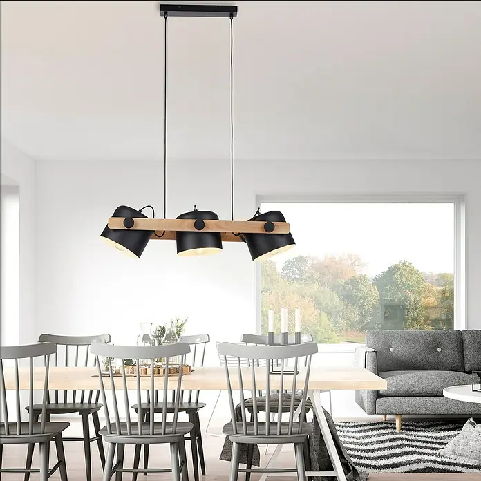 Just Light Cup Lámpara colgante - 180 W, L x An x Al: 23 x 70 x 120 cm, Negro/Madera, E27, 3 ud. - Una lámpara colgante moderna con tres pantallas negras ajustables unidas a una viga de madera cuelga sobre una mesa de comedor.