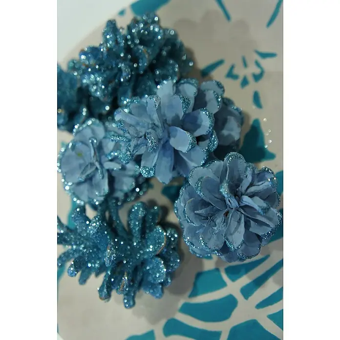 Fleur Purpurina Glitter - Light Blue, 90 g, Brillante - Primer plano de piñas azules brillantes dispuestas sobre una superficie estampada en azul y blanco, ideal para un toque festivo.