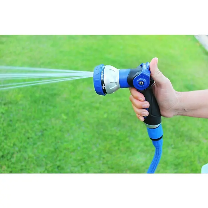 Kit de manguera en espiral Eva - Largo: 15 m, Plástico - Primer plano de una persona sosteniendo una manguera de jardín azul con boquilla de pulverización, rociando agua sobre un césped verde.