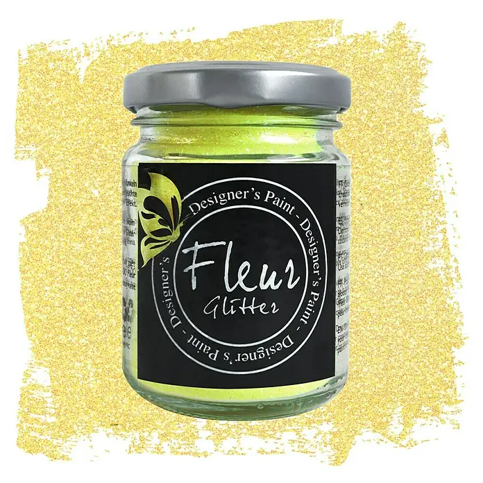 Fleur Purpurina Glitter - Giallo, 90 g, Brillante - Primer plano de un frasco de pintura de diseño Fleur Glitter sobre un fondo borroso y brillante.