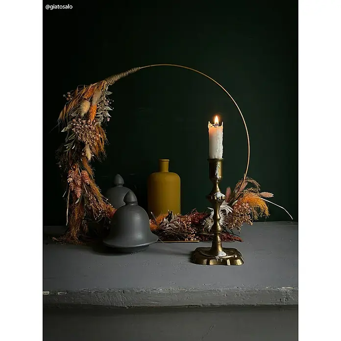 Fleur Pintura decorativa en spray Chalky Look - Amarillo Ocre, Mate, 300 ml - Naturaleza muerta atmosférica con candelabro, corona de flores secas y jarrones de cerámica decorativos sobre una mesa gris.