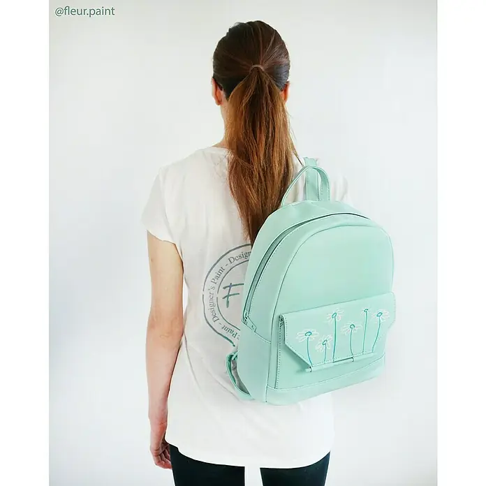 Fleur Pintura decorativa en spray Chalky Look - Capetown Azul, Mate, 300 ml - Primer plano de una mochila verde menta con diseño floral, portada por una mujer, ideal para uso diario y toques de estilo.