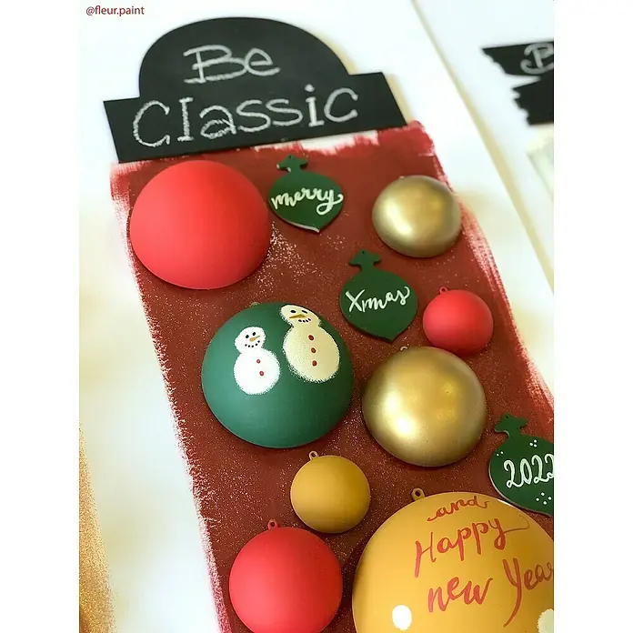 Fleur Pintura decorativa en spray Chalky Look - Verde Queen, Mate, 300 ml - Centros de mesa festivos con bolas de Navidad, adornos y saludos manuscritos sobre un fondo rústico pintado.