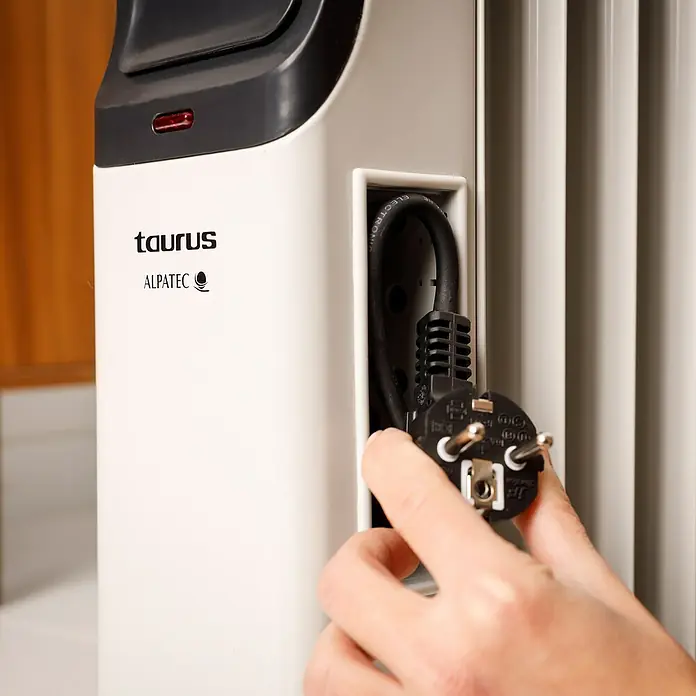 Taurus Ölradiator New Dakar1.500 W, Raumgröße bis ca. 15 m², Weiß - Nahaufnahme eines Taurus Alpatec Heizgeräts, das an einer Steckdose angeschlossen wird.