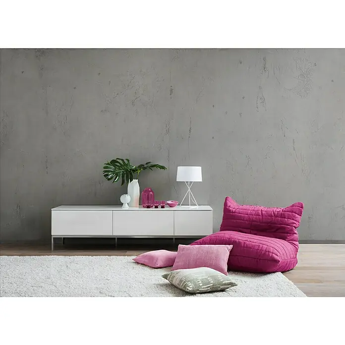 SCHÖNER WOHNEN-Farbe Trendstruktur Dekoputz-Set Sichtbeton-Optik - 3 -tlg. - Nahaufnahme eines stilvollen Wohnzimmers mit einem modernen weißen Sideboard, einer auffälligen Lampe und einem bequemen pinkfarbenen Sitzsack.