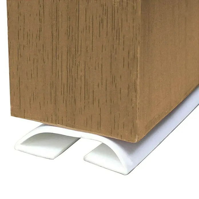 Junta para puerta Antipinzamiento - Blanco, Largo: 1 m - Primer plano de un protector de pata de mueble de plástico blanco debajo de una pata de madera.