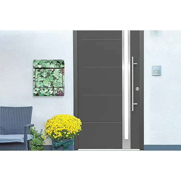 WandbriefkastenL x B x H: 12 x 38 x 45 cm, Stahl, Zeitungsfach, Efeu - Eine Nahaufnahme einer Hauswand mit einem Briefkasten mit Efeumuster, einer Tür und einem gelben Blumenarrangement.