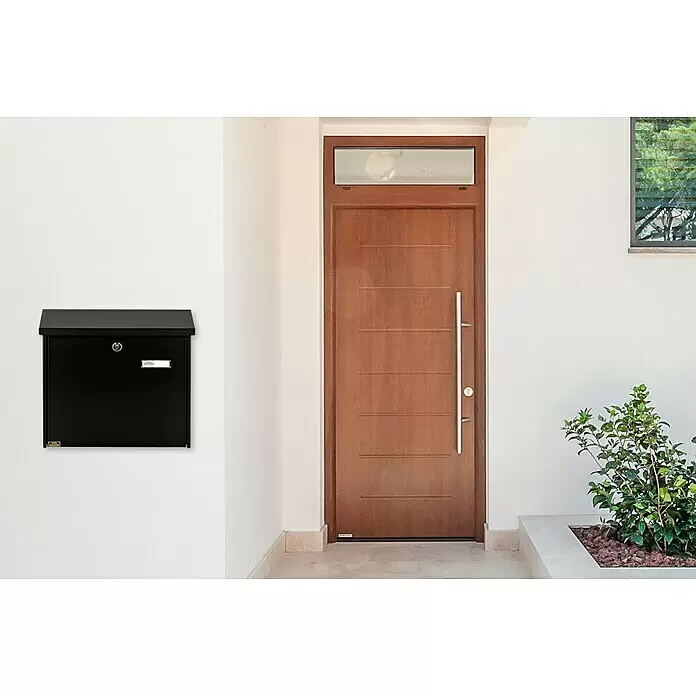Burg-Wächter Wandbriefkasten Comfort 913 - L x B x H: 38 x 14,8 x 34 cm, Schwarz, Stahl, Öffnungsstopp - Ein eleganter schwarzer Wandbriefkasten ist neben einer modernen Holzvordertür montiert.
