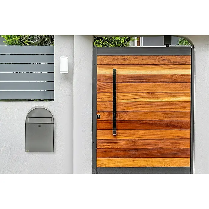 Burg-Wächter Wandbriefkasten Nordic 3680 - L x B x H: 30 x 22,2 x 47,5 cm, Silber, Edelstahl, Öffnungsstopp - Eine moderne Eingangstür mit Holzpaneelen und einem schlanken Griff, neben einem Briefkasten an einer weißen Wand.