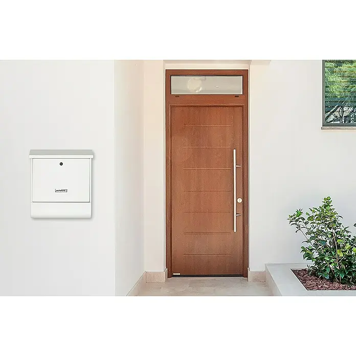 Portaferm Wandbriefkasten PF 77 - L x B x H: 11,5 x 38 x 42,5 cm, Weiß, Stahl, Zeitungsfach - Außenaufnahme eines modernen weißen Briefkastens an einer weißen Wand neben einer Haustür.