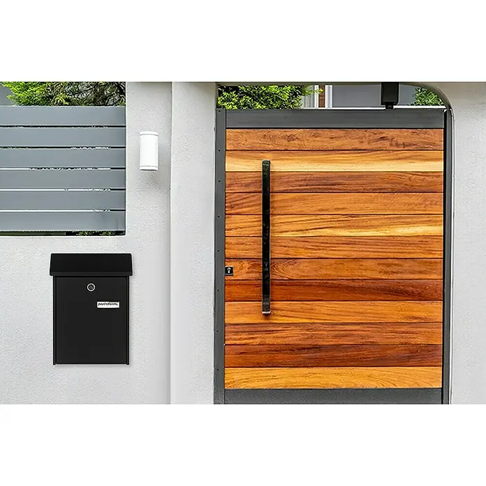 Portaferm Wandbriefkasten PF 22 - L x B x H: 7,5 x 22,5 x 30,5 cm, Schwarz, Stahl - Außenaufnahme eines modernen Briefkastens und eines Holztores, die ein stilvolles und funktionales Design vereinen.