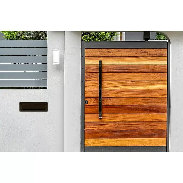 Burg-Wächter Einwurfblende Porta 796 - 304 x 101 mm, Aluminium, Braun - Dunkelbrauner Metall-Briefkastenschlitz in weißer Wand, neben modernem Holztor eingelassen.