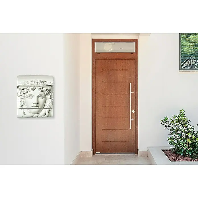 Wandbriefkasten - L x B x H: 12 cm x 380 mm x 45 cm, Stahl, Zeitungsfach, Medusa - Eine stilisierte Medusa-Briefkasten-Skulptur an einer weißen Wand neben einer Haustür und einem Fenster, die das Äußere des Hauses betonen.