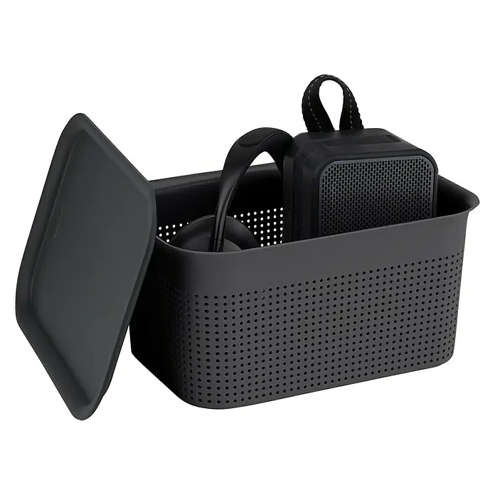 Rotho Aufbewahrungsbox Brisen - L x B x H: 26,2 x 18 x 13 cm, Kunststoff, Anthrazit - Nahaufnahme eines schwarzen Korbes mit Kopfhörern und einem Lautsprecher darin, mit einem Deckel daneben auf schwarzem Hintergrund.