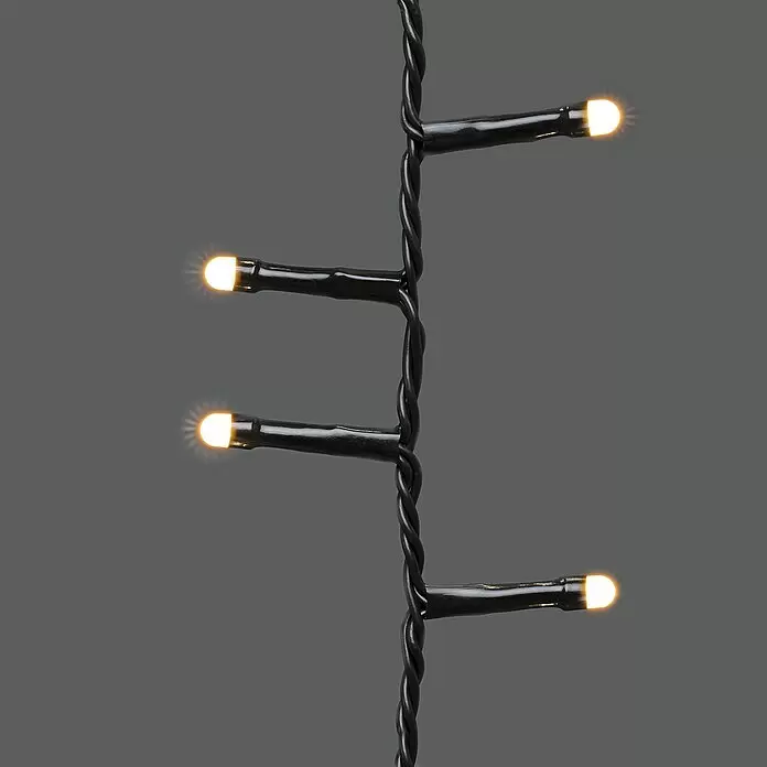 Konstsmide Baummantel - Außen, 2,4 m, 6 Stränge à 110 gefrostete bernsteinfarbene LEDs, Anzahl Leuchtmittel: 660 Stk., Lichtfarbe: Bernstein - Schwarze Lichterkette mit leuchtenden warmweißen LED-Birnen.