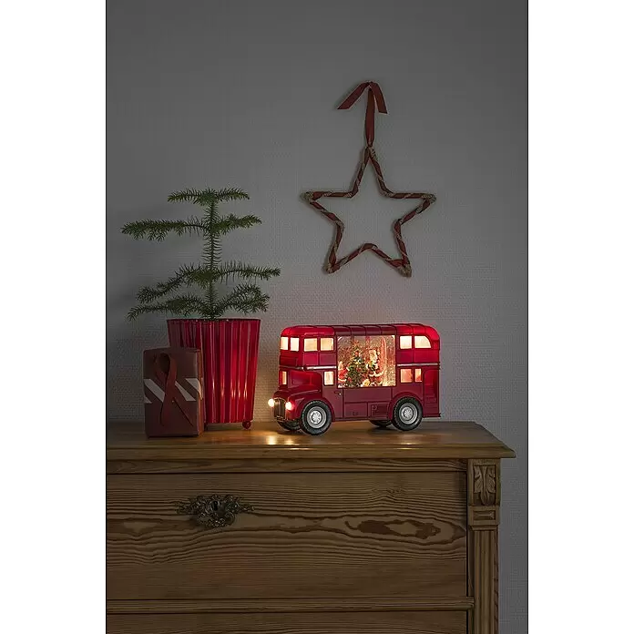 Konstsmide LED-Weihnachtsdekofigur Bus - 29,5 x 18,5 cm - Beleuchtete rote Doppeldeckerbus-Weihnachtsdekoration mit Weihnachtsmann und Baum auf einer Holzkommode.