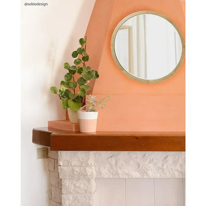 Fleur Pintura para efectos decorativos Lime Paint - Grand Canyon, 750 ml, Mate - Primer plano de un interior con espejo, plantas en una chimenea de piedra blanca y paredes de colores.