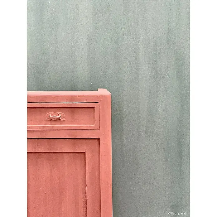 Fleur Pintura para efectos decorativos Lime Paint - Amelie, 750 ml, Mate - Primer plano de un armario vintage color coral con un cajón sobre un fondo verde menta. Mobiliario único para acentos elegantes.