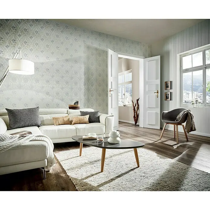 Marburg Home Classic Belvedere Vliestapete Blockstreifen - Grau, Streifen, 10,05 x 0,53 m - Wohnzimmer mit weißem Sofa, Teppich und grauem Sessel. Die Tapete hat ein florales Muster.