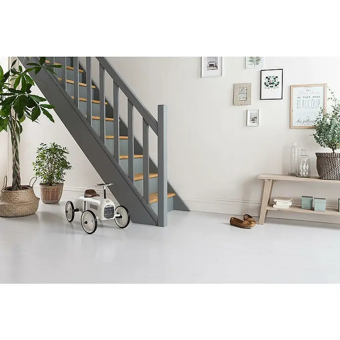 V33 Esmalte de color Renovation Perfection suelos de cerámica - Marrón topo, Satinado, 2 l - Un interior luminoso con una escalera gris, plantas y un coche de juguete vintage. Una escena decorativa en el hogar.