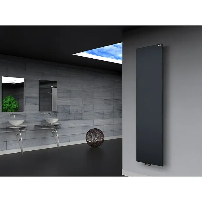 Szagato Designheizkörper Manhattan 3 - B x H: 470 x 1.800 mm, Anthrazit, Ohne Handtuchhalter - Schwarzer Badheizkörper an einer grauen Wand in einem Badezimmer mit Waschbecken und Spiegel. Das moderne Design passt perfekt zum eleganten Stil.