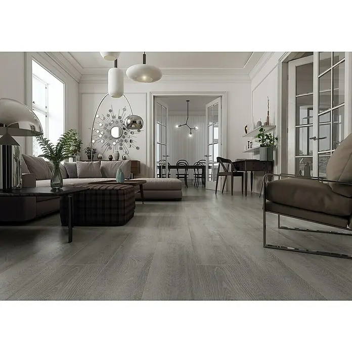 LOGOCLIC Laminado Roble Wembley - 1.380 x 193 x 10 mm, AC4 - Espacio de vida luminoso con pisos de madera gris. El interior elegante incluye un sofá, sillones y elementos decorativos que crean un ambiente moderno.