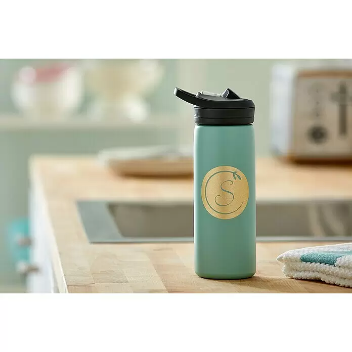 Cricut Joy Schneideplotter Starter Bundle - Türkis/Weiß, Bluetooth, Schnittbreite: 10,4 cm, Schnittlänge: 1,2 m - Eine tealfarbene Wasserflasche mit schwarzem Klappverschluss und goldenem 'S'-Monogramm steht auf einer Küchenarbeitsplatte.