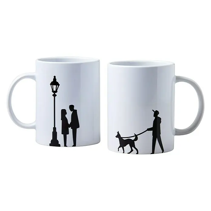 Cricut Transferpresse Mug Press Starter Bundle - Weiß, USB-Kabel - Zwei weiße Tassen mit einer schwarzen Silhouette von einem Paar unter einer Straßenlaterne und einer Person, die mit einem Hund spazieren geht.