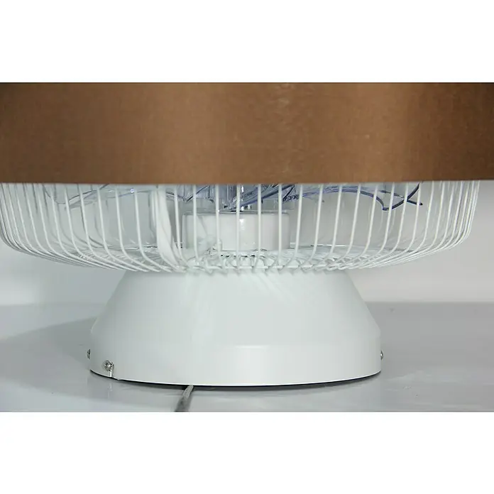 Voltomat Deckenventilator mit LED-Beleuchtung - Braun/Silber, 57 cm, 40 W - Nahaufnahme eines weißen Tischventilators mit Schutzgitter, teilweise verdeckt durch einen braunen Gegenstand.