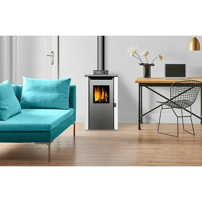 Estufa de pellets Lake K7 - 6 kW, Volumen de calefacción: 150 m³, Blanco/Antracita - La imagen muestra una chimenea moderna en un espacio habitable elegante, con sofá, escritorio y silla. La chimenea proporciona calidez y ambiente.