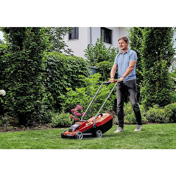 Einhell Power X-Change 18V Akku-Rasenmäher GE-CM 18/32 Li-Solo - 18 V, Ohne Akku, Schnittbreite: 32 cm - Ein Mann mäht den Rasen mit einem roten und schwarzen Rasenmäher im Garten.