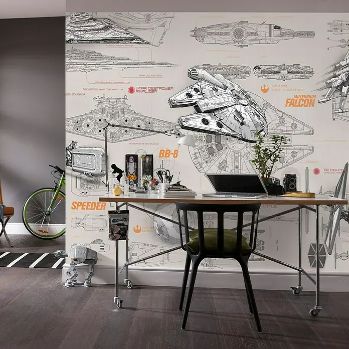Komar Star Wars Fototapete Blueprints - 8 -tlg., B x H: 368 x 254 cm, Papier - Ein Arbeitszimmer im Star Wars-Stil mit einem Schreibtisch vor einer Tapete mit Raumschiff-Blaupausen und einem Millennium Falcon Modell.