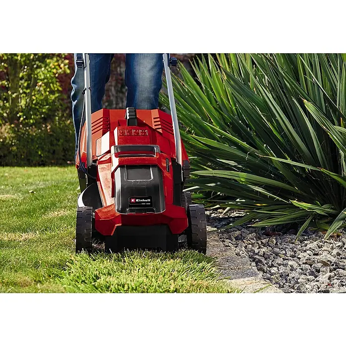 Einhell Power X-Change 18V Akku-Rasenmäher GE-CM 18/32 Li-Solo - 18 V, Ohne Akku, Schnittbreite: 32 cm - Der Einhell Akku-Rasenmäher ist rot und schwarz und wird von einer Person auf einem Rasen bedient.