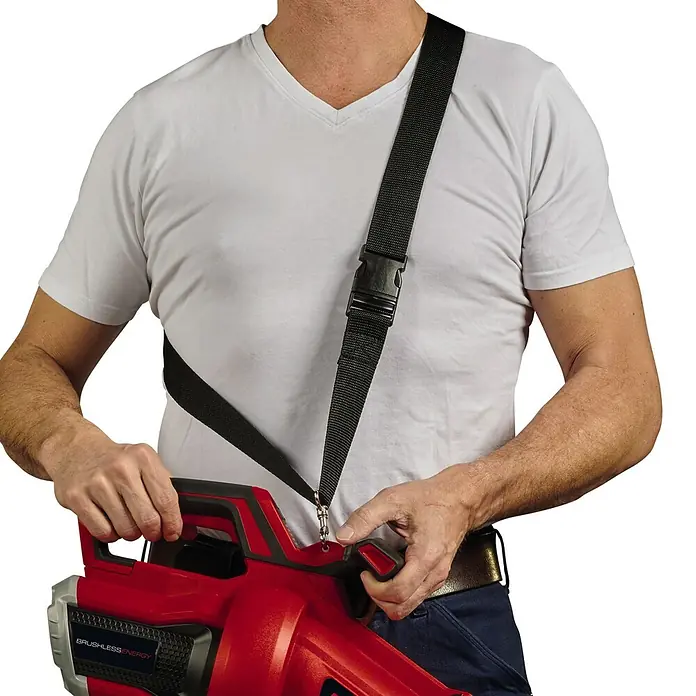 Einhell Professional PXC 18V Soplador/Aspirador de batería VENTURRO 36/240 - 18 V, Sin batería, Velocidad de soplado: 240 km/h - Primer plano de una persona que sujeta un soplador de hojas inalámbrico con una correa para el hombro. La correa permite transportar cómodamente el aparato.