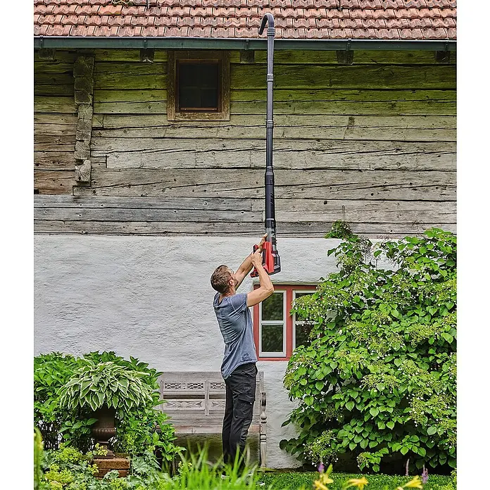 Einhell Professional Akku-Laubbläser GP-LB 18/200 Li GK-Solo18 V, Ohne Akku, Blasgeschwindigkeit: 200 km/h, Blasleistung: 670 m³/min - Ein Mann benutzt einen Laubbläser mit Teleskopstiel zur Reinigung einer Dachrinne an einem Haus.