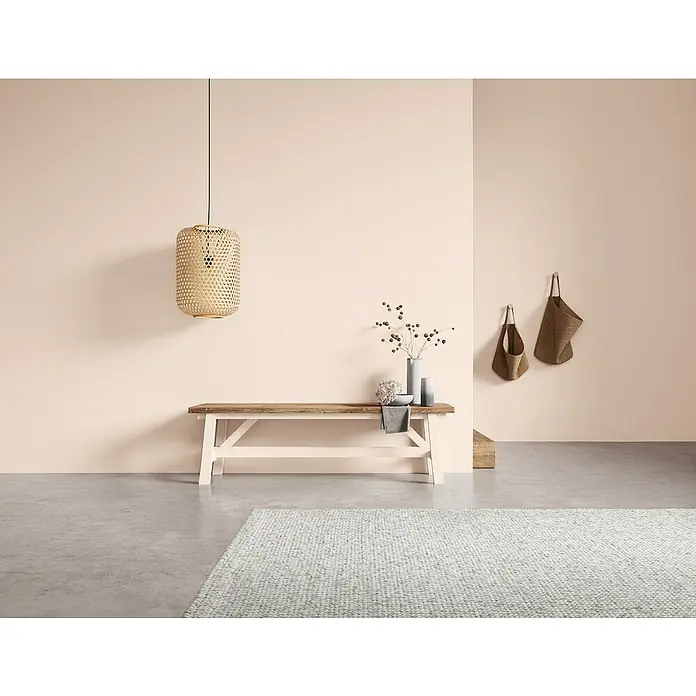 SCHÖNER WOHNEN-Farbe Naturell Wandfarbe KreidefarbeRosenduft - dezentes Hellrosa, Matt, 1 l, Konservierungsmittelfrei - Stillleben mit einer hellen Holzbank, einer Rattanlampe und dekorativen Elementen, die eine ruhige und einladende Atmosphäre schaffen.