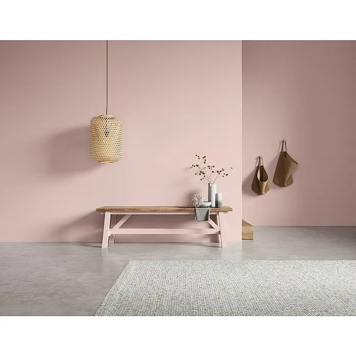 SCHÖNER WOHNEN-Farbe Naturell Wandfarbe KreidefarbeKirschblütenmeer - zartes Rosa, Matt, 1 l, Konservierungsmittelfrei - Einladendes Interieur mit einer stilvollen Holzbank, einer dekorativen Hängeleuchte und einer sanften Farbpalette, die eine beruhigende Atmosphäre schafft.