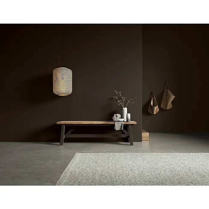 SCHÖNER WOHNEN-Farbe Naturell Wandfarbe KreidefarbeNachthimmel - sanftes Anthrazit, Matt, 1 l, Konservierungsmittelfrei - Stimmungsvolles Interieur mit einer rustikalen Holzbank, einer dekorativen Hängelampe und einer einladenden Atmosphäre in dunklen Farbtönen.