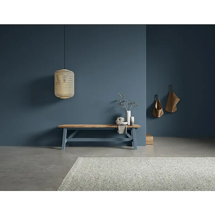 SCHÖNER WOHNEN-Farbe Naturell Wandfarbe KreidefarbeWellenklang - dunkles Blau, Matt, 1 l, Konservierungsmittelfrei - Stimmungsvolles Interieur mit einer rustikalen Holzbank unter einer dekorativen Bambuslampe.