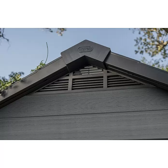 Keter Gerätehaus Newton 7511 - Außenmaß inkl. Dachüberstand (B x T): 228 x 350 cm, Kunststoff, Schiefergrau, 7,98 m² - Nahaufnahme des dunkelgrauen Giebels eines Keter-Gartenschuppens mit Lüftungsgitter und Holzmaserungs-Kunststoffplatten.