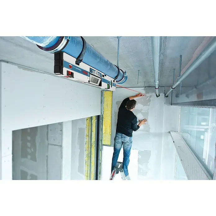Bosch Professional Digitale Wasserwaage GIM 60 L - Länge: 61,8 cm - Ein Mann steht auf einer Leiter und benutzt einen Bosch Professional GOL 32 D Baulaser, der an einem Rohr befestigt ist, um Markierungen an einer Wand anzubringen.