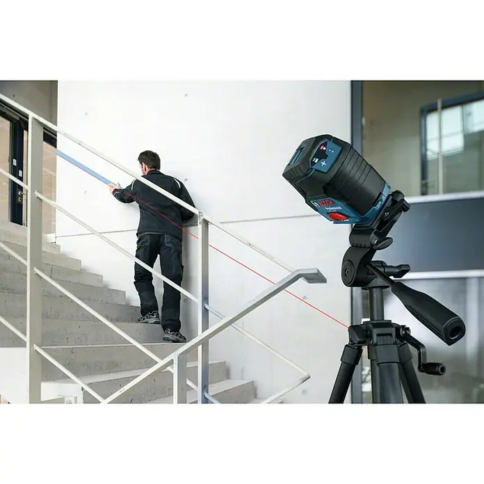 Bosch Professional Kombilaser GCL 2-50 C - Max. Arbeitsbereich: 50 m, 6 -tlg. - Der Bosch Professional GLL 3-80 CG Linienlaser auf einem Stativ projiziert rote Laserlinien für präzise Nivellierung an einer Treppe.