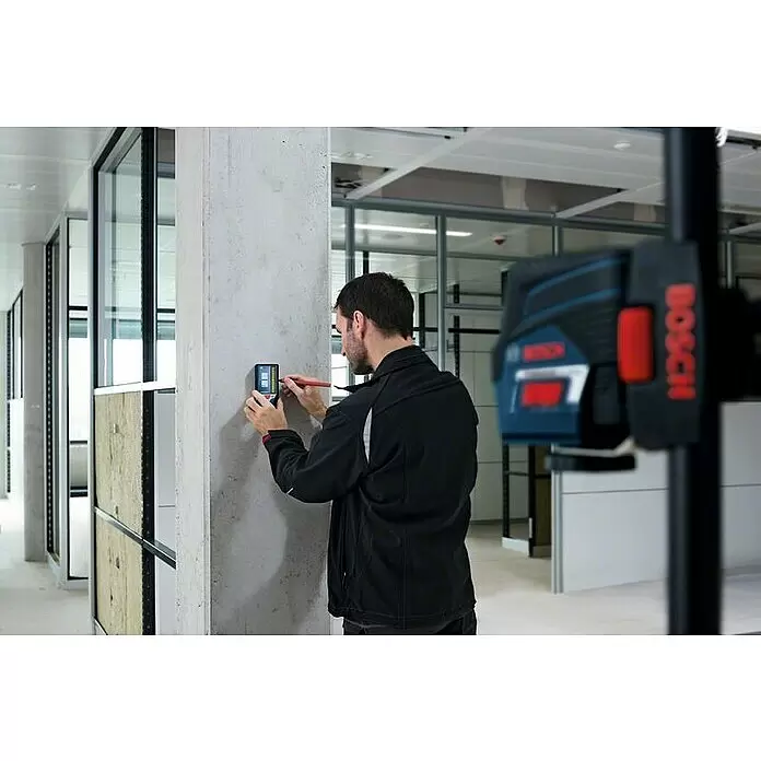 Bosch Professional Laserempfänger LR 7 - Passend für: Verschiedene Bosch Professional Kombi- und Linienlaser der GCL und GLL Serie - Mann nutzt Bosch-Ortungsgerät an Betonsäule und markiert. Ein Bosch-Laser-Nivelliergerät ist ebenfalls sichtbar.