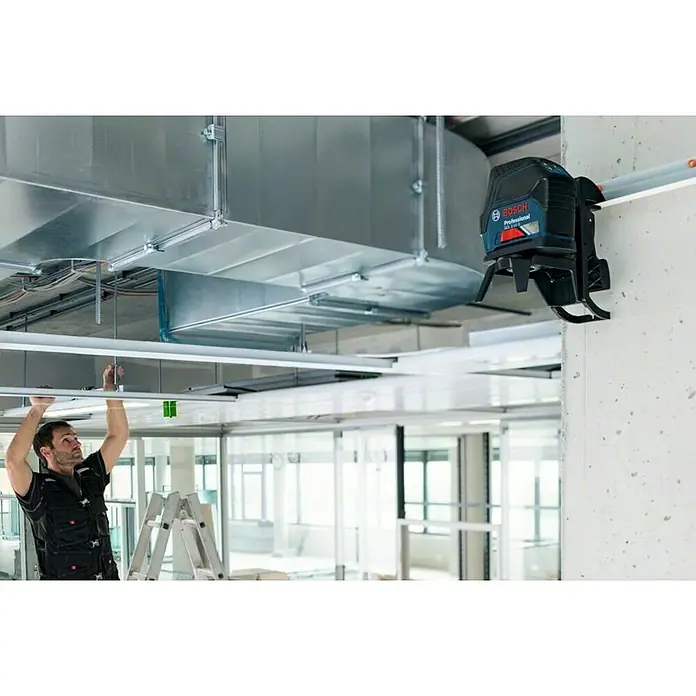 Bosch Professional Kombilaser GCL 2-15 - Arbeitsbereich: Ca. 15 m, 6 -tlg. - Ein Bosch Professional GCL 2-50 G Kreuzlinienlaser an der Wand befestigt, ideal für präzise Ausrichtung und Nivellierung auf der Baustelle.