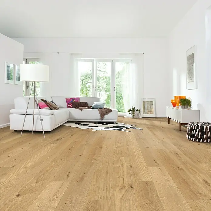 Living by Haro Parkettmuster Eiche geölt strukturiert - 290 x 180 x 12 mm, Landhausdiele - Helles Wohnzimmer mit modernem Eichenparkettboden, weißer Couch und minimalistischer Einrichtung für ein freundliches Ambiente.