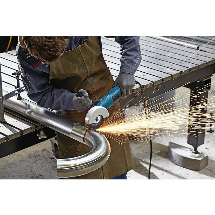 Bosch Professional Elektro-Winkelschleifer GWS 17-125 - 1.700 W, Durchmesser Scheibe: 125 mm, Leerlaufdrehzahl: 11.500 U/min - Ein Arbeiter mit Schutzkleidung schneidet ein Metallrohr mit einem blauen Bosch Winkelschleifer, Funken sprühen.