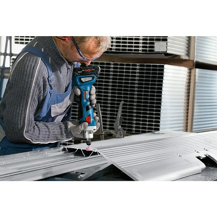 Bosch Professional AMPShare 18V Akku-Geradschleifer GGS 18V-20 - 18 V, Ohne Akku, Leerlaufdrehzahl: 24.000 U/min, Karton - Ein Handwerker benutzt einen Bosch Professional Akku-Geradschleifer GGS 18V-23 LC, um Metall zu bearbeiten. Schutzkleidung ist getragen.