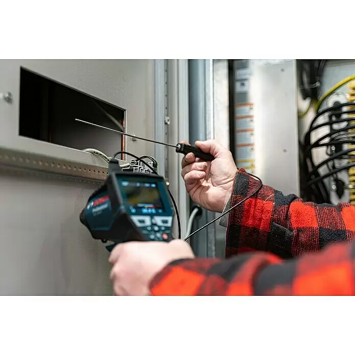 Bosch Professional Thermodetektor GIS 1000 C - 1 Akku, Messbereich Temperatur: -40 °C - 1.000 °C - Person im roten Holzfällerhemd inspiziert einen Schaltschrank mit einer Bosch-Wärmebildkamera und einer langen Metallsonde.